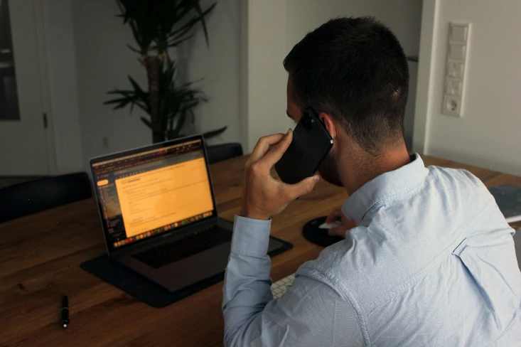 man in blauwe overhemddas met zwarte smartphone